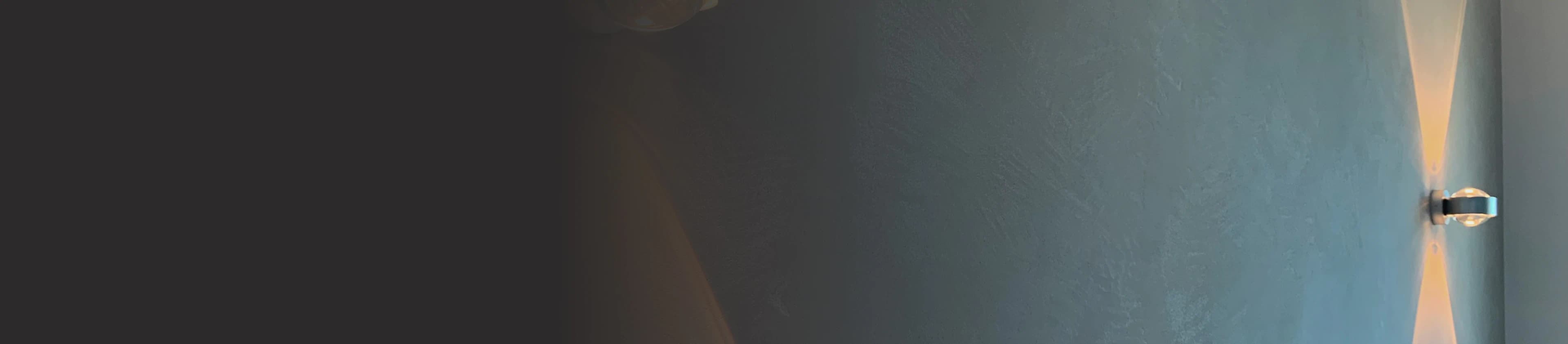 Graue Wand mit Occhio-Lampen